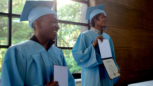 Monte Cosby (left) and Tavon Watson display their diplomas during the high school graduation ceremony at Legacy Academy.